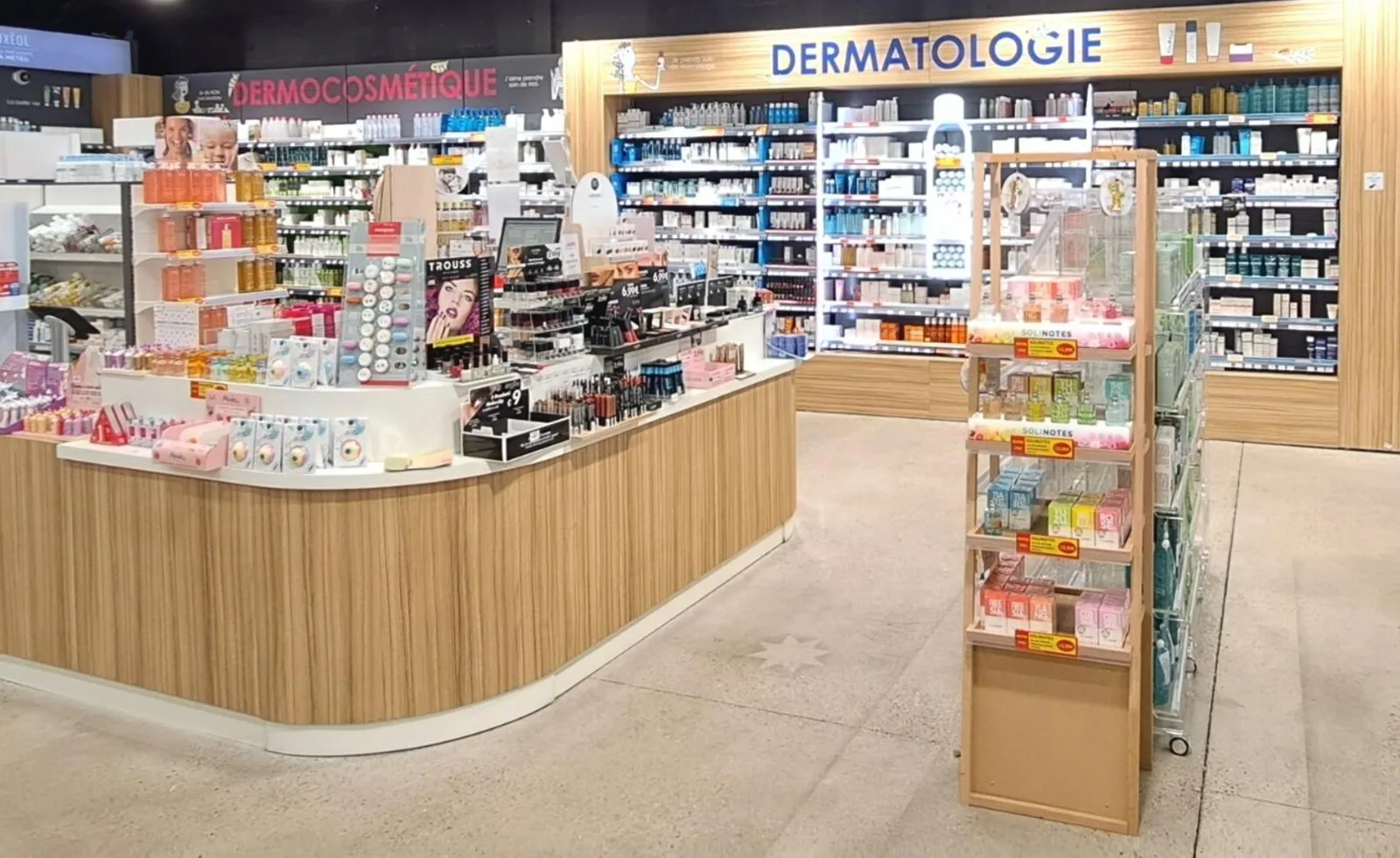 Comptoir et mobilier en bois sur mesure dans l'espace dermocosmétique d'une pharmacie agencée par Kollirama